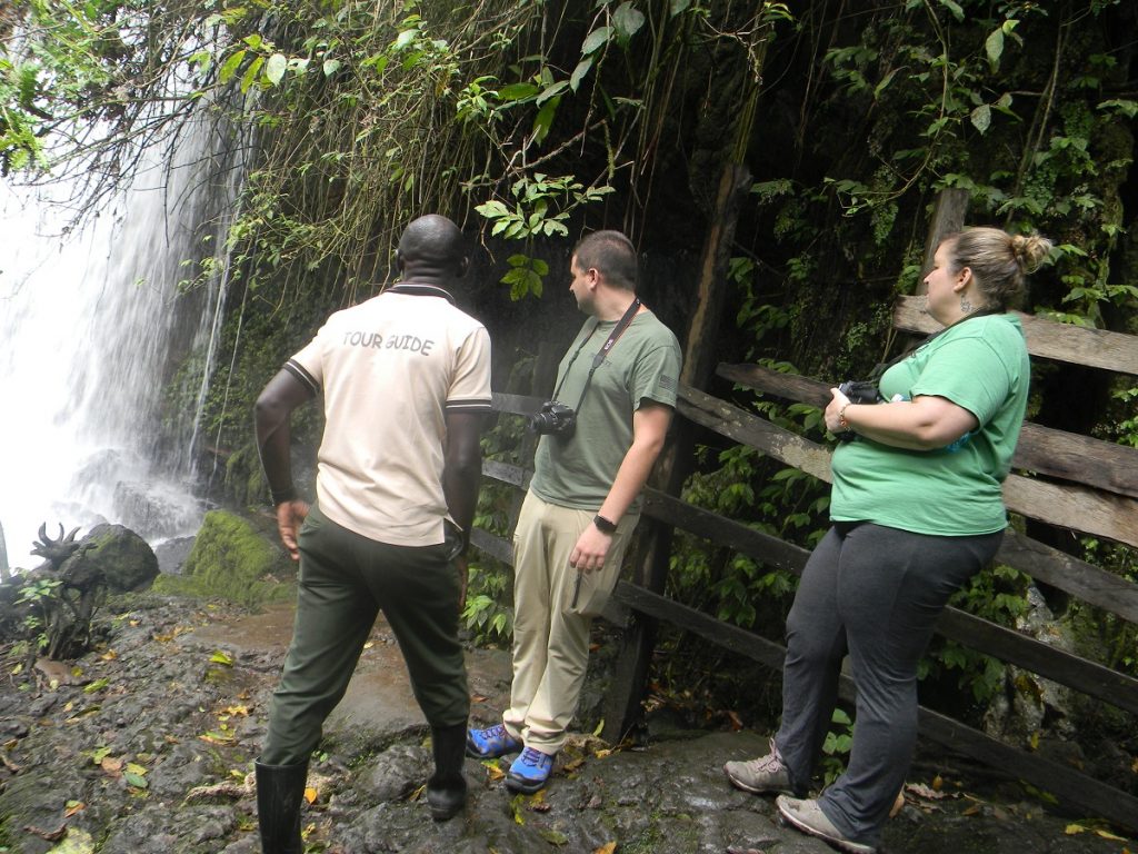 Visitors exploring Nyakasura falls at Amabeere ga Nyinamwiru. Credit: Self Drive Car Hire
